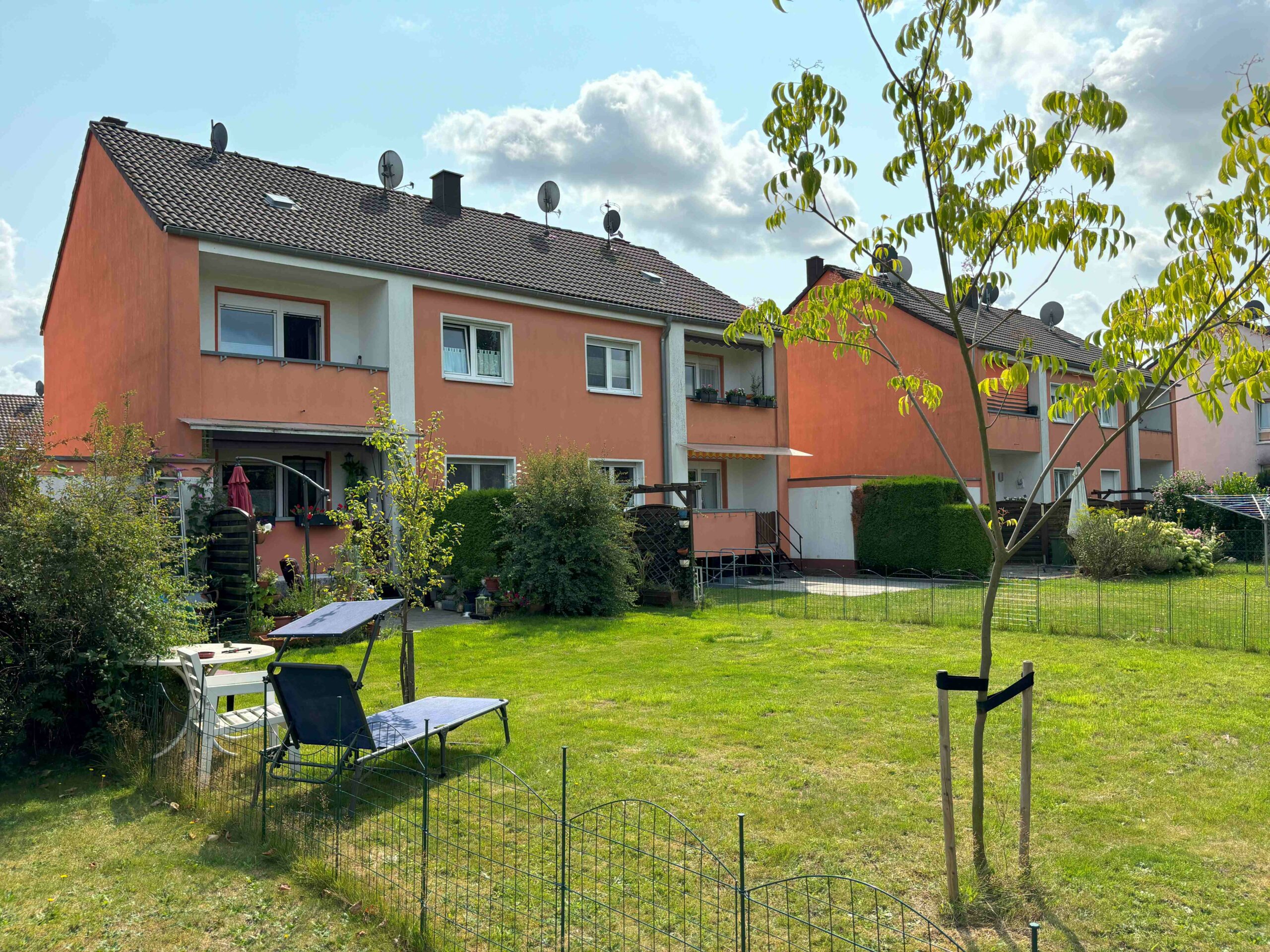 Das Bild zeigt die Gartenansicht von mehreren Wohneinheiten.