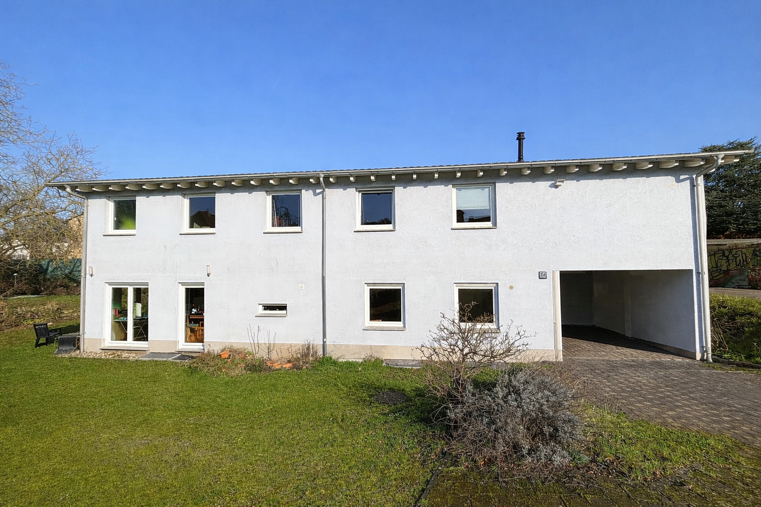 Das Bild zeigt die Außenansicht eines verputzten Einfamilienhauses.