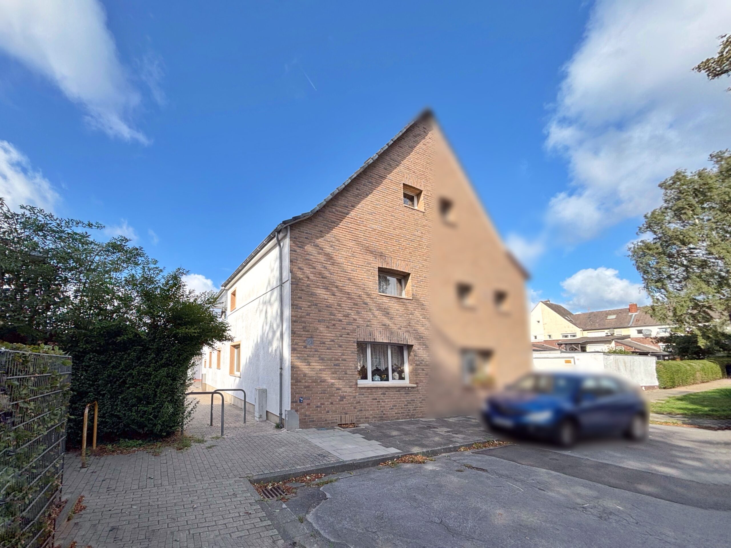 Das Bild zeigt eine Haushälfte, vorne verklinkert die Seite weiß verputzt.