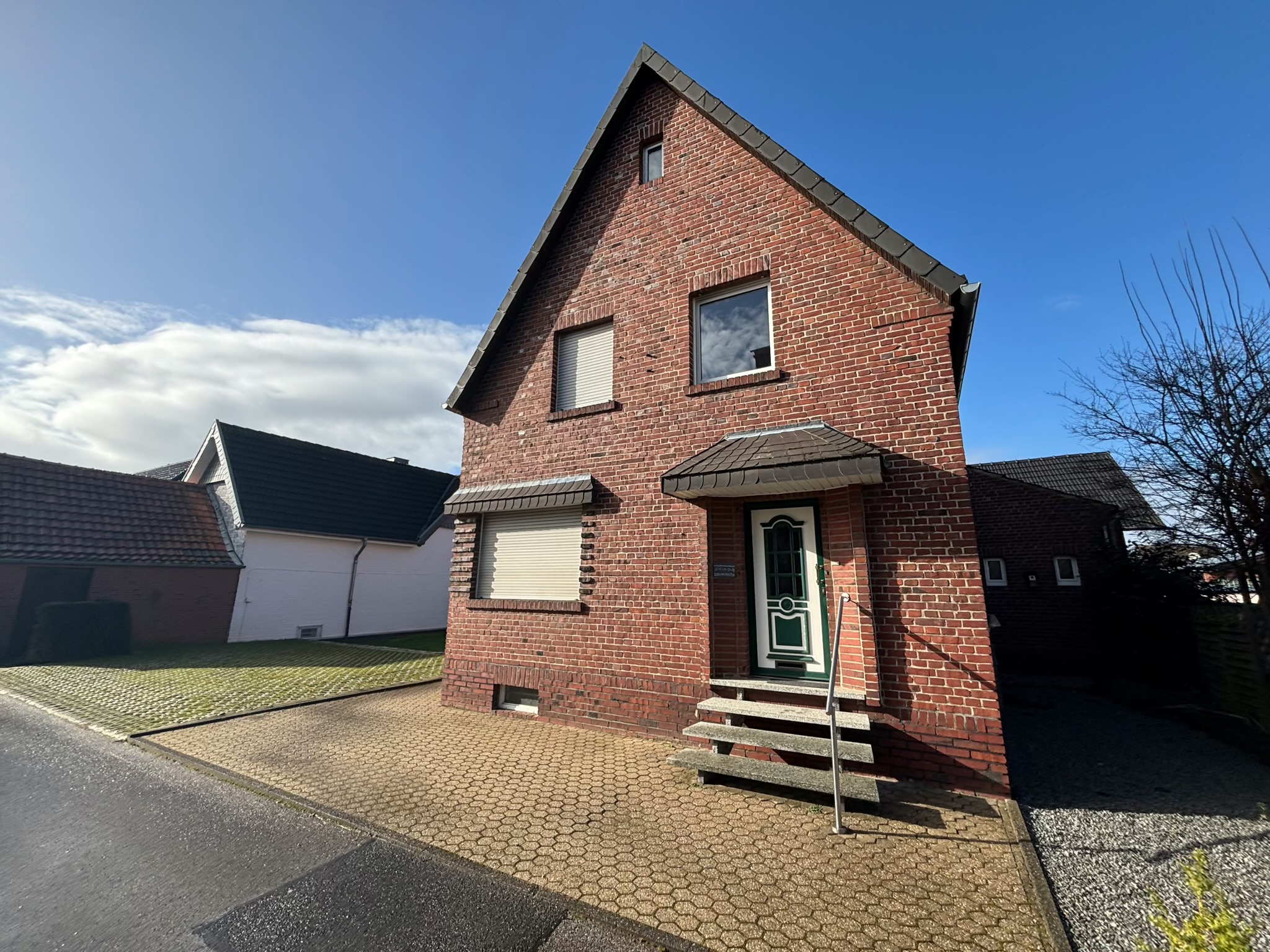 Das Bild zeigt die Außenansicht eines verklinkerten Einfamilienhauses.