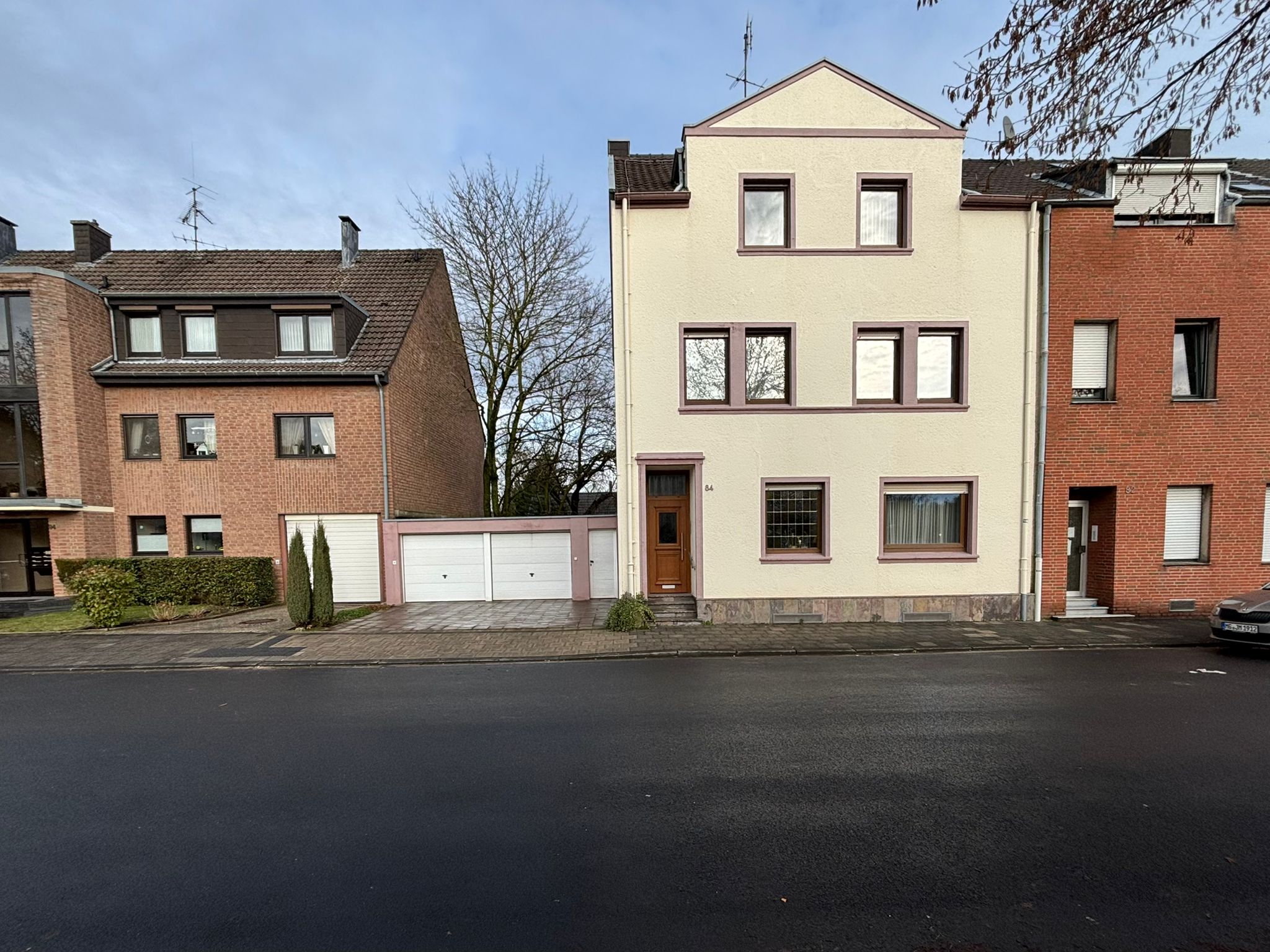 Das Bild zeigt die Außenansicht eines hell verputzten Zweifamilienhauses.