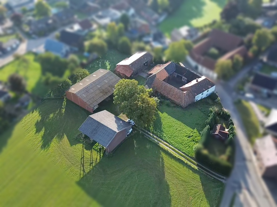 Das Bild zeigt die Luftaufnahme des großzügigen Grundstücks mit Wohnhaus und Hallen.
